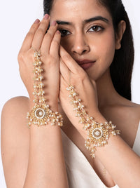 Aadhira Pearl Bridal Haathphool handcrafted with faux pearls, glass bead clusters, and brass metal in a Gold Tone Finish, featuring a floral centerpiece with cascading pearl strands, adjustable finger ring, and bracelet design, perfect for weddings, mehendi, haldi, receptions, and bridal styling.