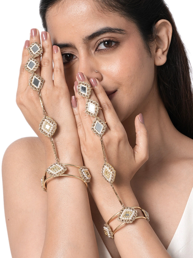 Aarini Mirror Bridal Haathphool handcrafted with geometric mirror motifs, faux pearls, glass bead detailing, and brass metal in a Gold Tone Finish, featuring adjustable finger rings and an open bangle, perfect for weddings, mehendi, haldi, receptions, festive occasions, and bridal styling.