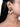 Aashvi Antique Bridal Earrings featuring intricate antique gold beadwork, pearl detailing and cascading white seashell danglers, styled on a woman.