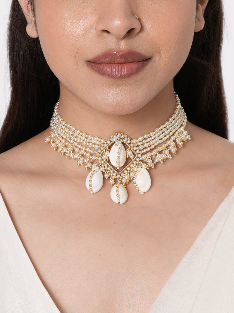 Alaya Cowrie Shell Choker handcrafted with layered faux pearl strands, natural cowrie shell centerpiece, cascading shell drops, intricate glass bead detailing, and a Gold Tone Finish, perfect for Haldi, Mehndi, weddings, receptions, destination weddings, and elegant bridal styling.