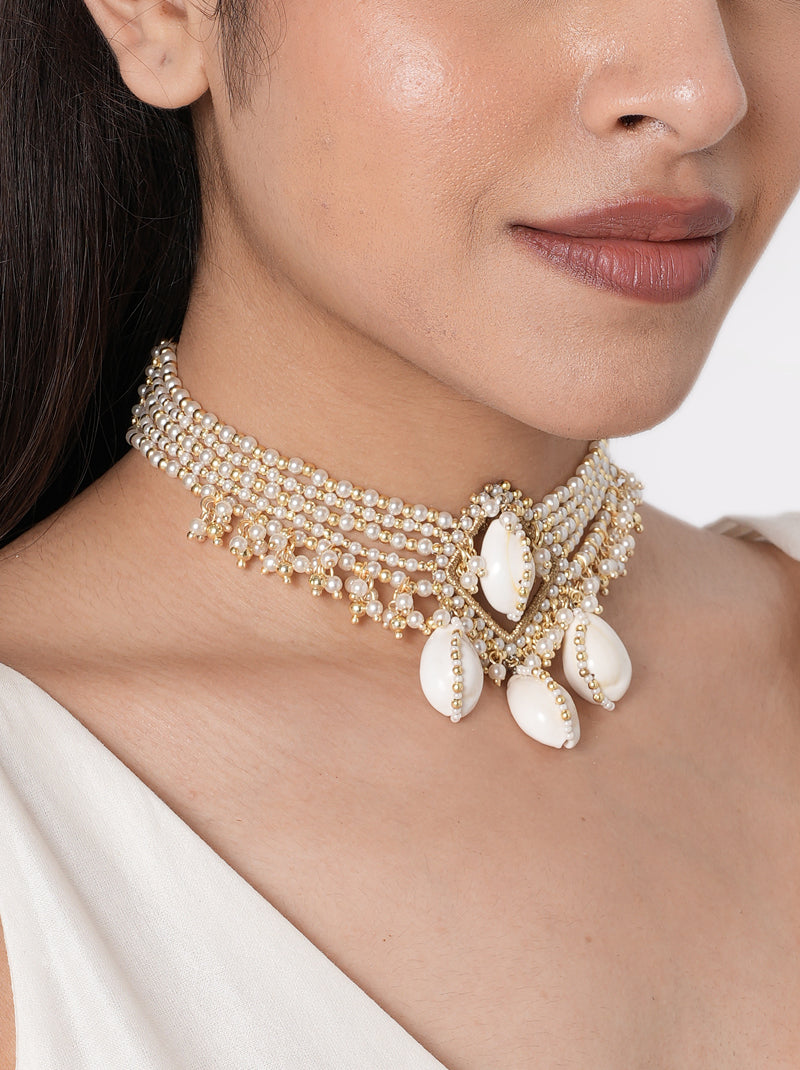Alaya Cowrie Shell Choker handcrafted with layered faux pearl strands, natural cowrie shell centerpiece, cascading shell drops, intricate glass bead detailing, and a Gold Tone Finish, perfect for Haldi, Mehndi, weddings, receptions, destination weddings, and elegant bridal styling.