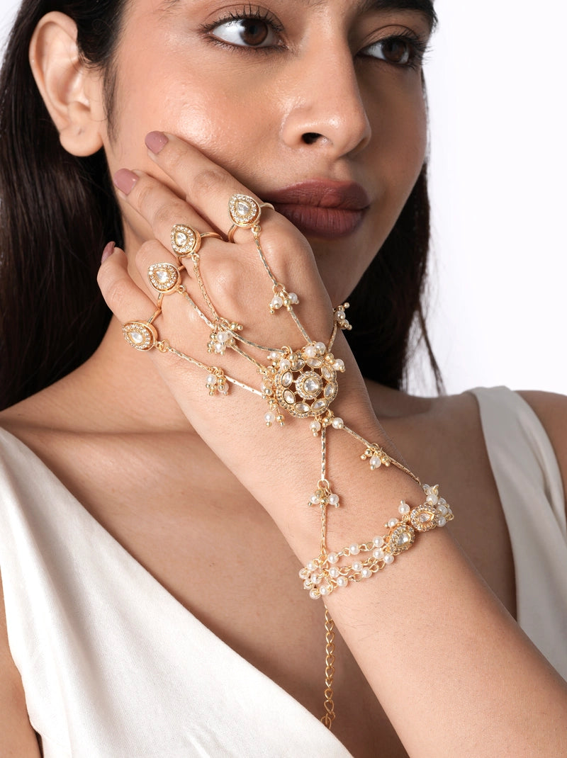 Ameya Pearl Bridal Haathphool handcrafted with faux pearls, glass stones, delicate glass bead detailing, floral motifs, fine chain accents, and a Gold Tone Finish, perfect for weddings, mehendi, haldi, receptions, festive occasions, and elegant bridal styling.