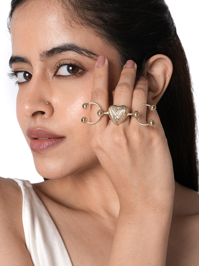Aurielle Heart Statement Ring handcrafted in brass metal with a Gold Tone Finish, featuring a textured heart centerpiece and adjustable double finger design, perfect for parties, gifting, festive occasions, and contemporary styling.