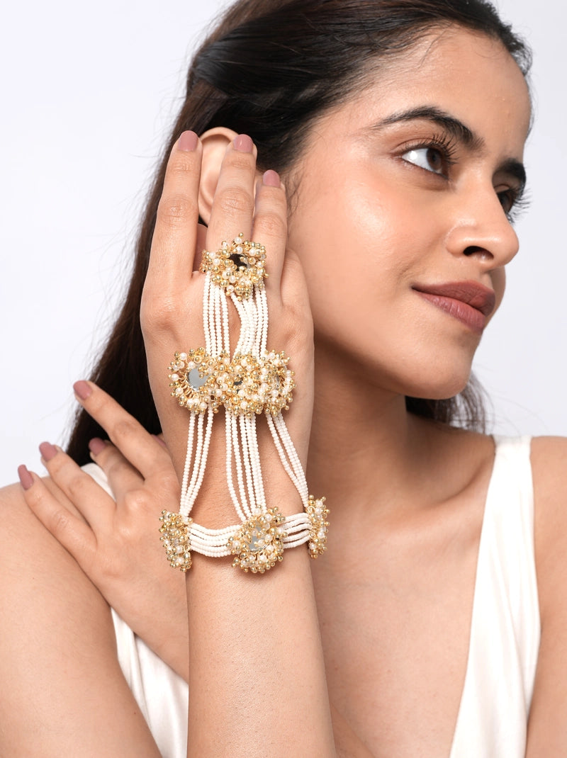 Avira Minimal Bridal Haathphool handcrafted with layered faux pearl strands, floral glass stone motifs, brass metal detailing, and a Gold Tone Finish, perfect for bridal wear, weddings, mehendi, haldi, receptions, and festive celebrations.