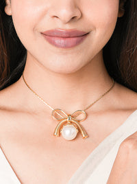 Bow Pearl Pendant Necklace handcrafted with a faux pearl centerpiece and elegant bow design in a gold tone finish for contemporary everyday and occasion styling.