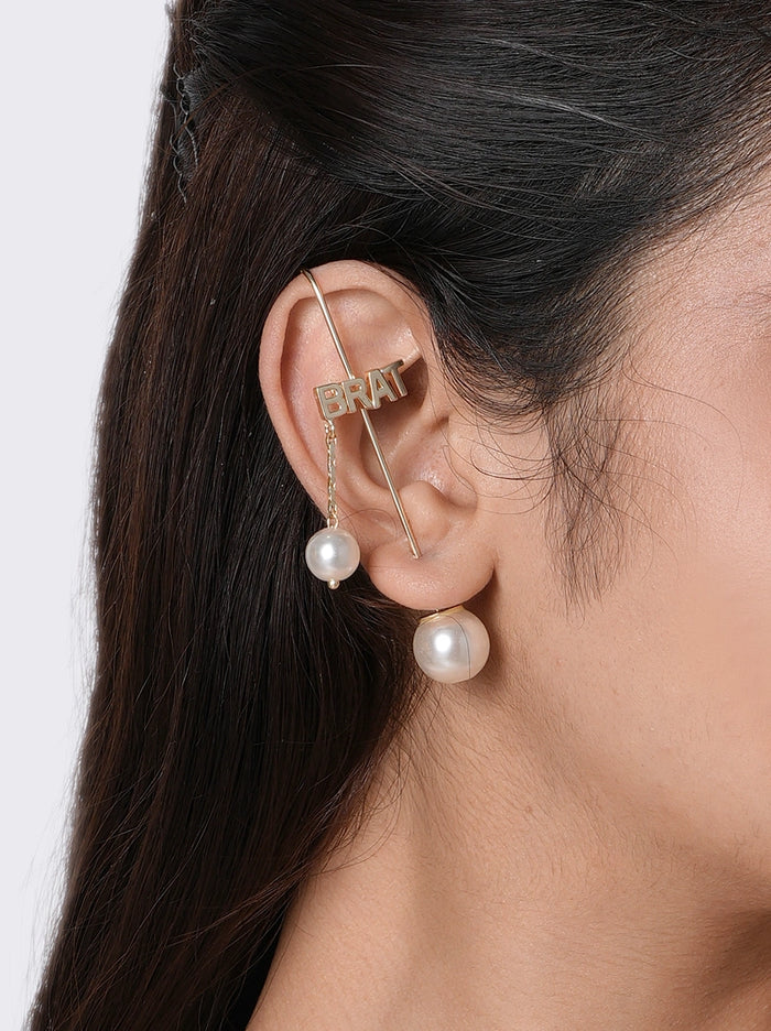 Brat Moodcuff handcrafted in brass metal with bold BRAT lettering, dangling faux pearl charm and Gold Tone Finish, perfect for parties, birthdays, vacations, festive occasions and contemporary statement styling.