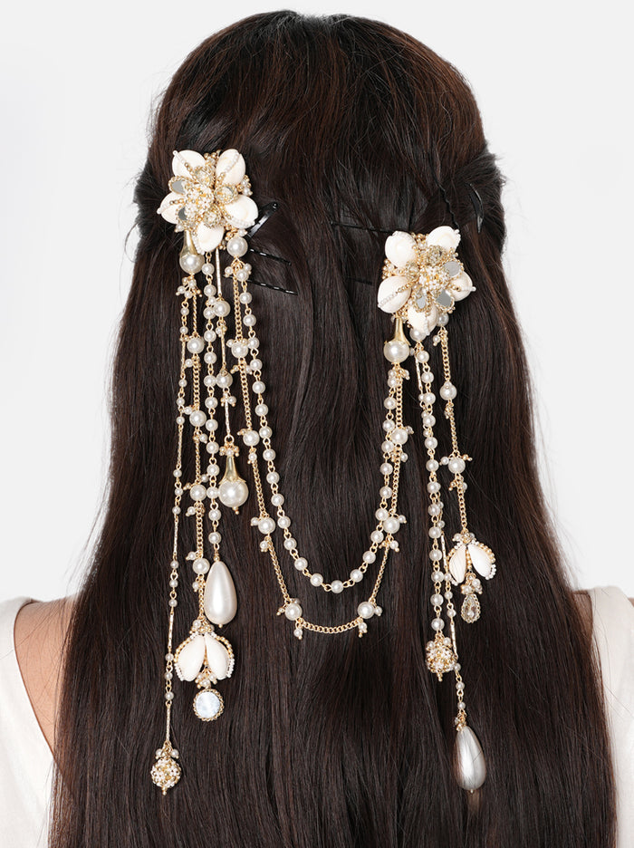 Chahat Floral Hair Accessory pair handcrafted with floral shell motifs, mirror accents, cascading faux pearl chains, glass bead detailing, and a Gold Tone Finish, perfect for Haldi, Mehndi, weddings, receptions, destination weddings, and elegant bridal hairstyles.