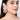 Charvi Floral Shell Earrings featuring cowrie shell floral motifs, faux pearl detailing, ear chain support and a gold tone finish for bridal and festive wear.