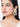 Charvi Floral Shell Earrings featuring cowrie shell floral motifs, faux pearl detailing, ear chain support and a gold tone finish for bridal and festive wear.
