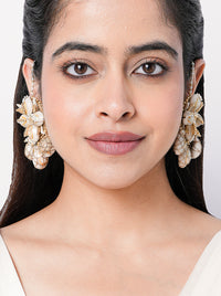 Charvi Floral Shell Earrings featuring cowrie shell floral motifs, faux pearl detailing, ear chain support and a gold tone finish for bridal and festive wear.