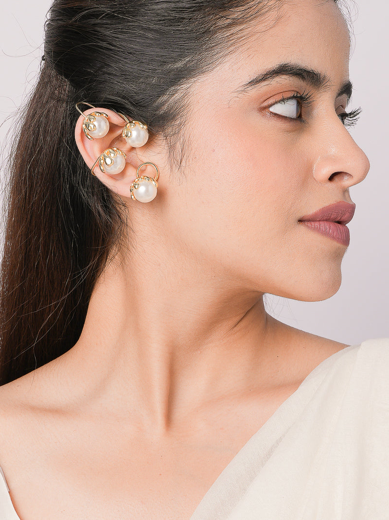 Woman wearing a designer gold-tone Sia Designer Pearl Earcuff featuring multiple ivory pearls arranged along a contemporary ear-climbing silhouette.