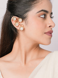 Woman wearing a designer gold-tone Sia Designer Pearl Earcuff featuring multiple ivory pearls arranged along a contemporary ear-climbing silhouette.