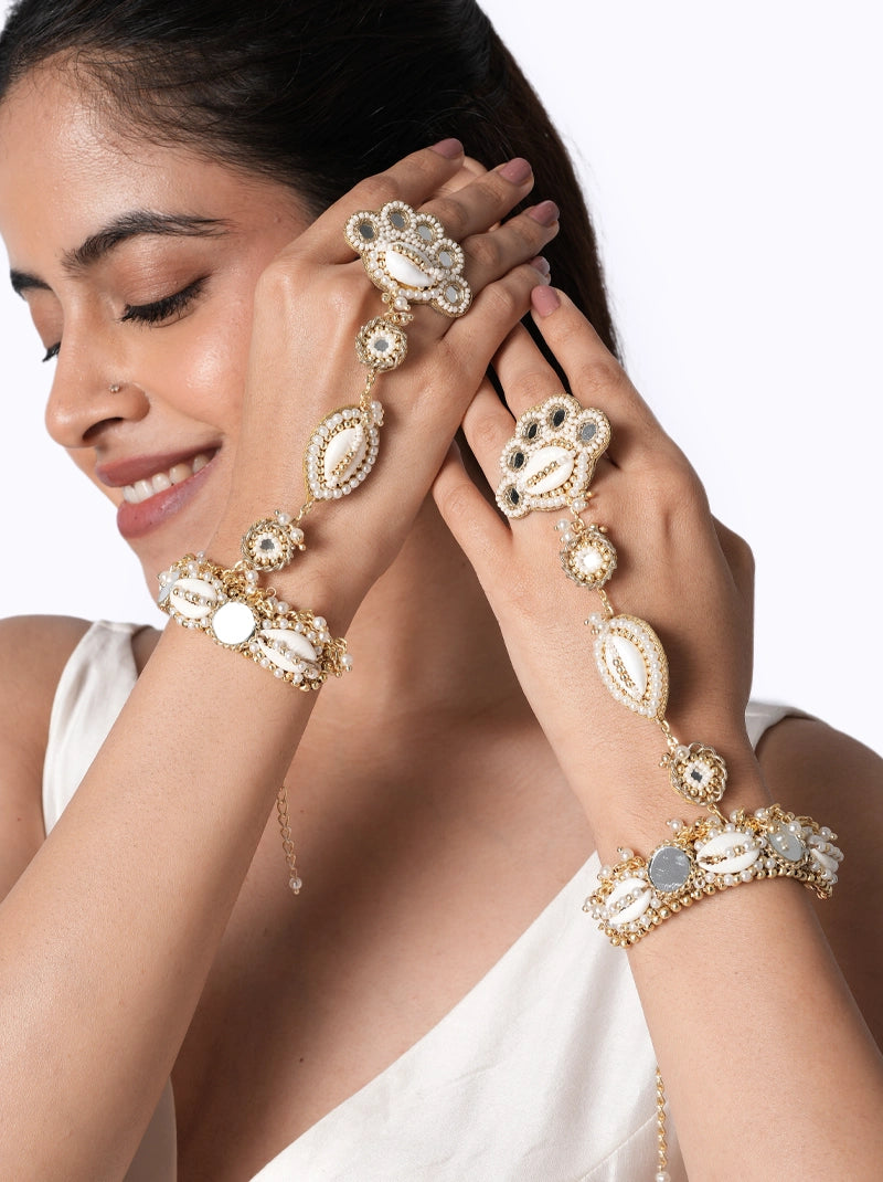 Dwani Shell Mirror Hathphool handcrafted with natural shell accents, mirror details, faux pearls, glass bead embroidery, and a Gold Tone Finish, perfect for haldi ceremonies, destination weddings, festive occasions, and contemporary bridal styling.