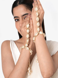 Gopi Cowrie Shell Hathphool handcrafted with natural cowrie shells, faux pearls, intricate glass bead embroidery, an elegant hand chain, cascading shell tassels, and a Gold Tone Finish, perfect for Haldi, Mehndi, weddings, receptions, destination weddings, and bridal hand styling.