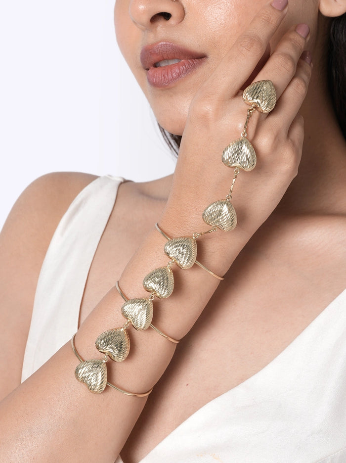 Hansi Handcrafted Heart Hathphool crafted from textured brass metal heart motifs with a Gold Tone Finish, featuring an adjustable ring and open cuff design, perfect for weddings, festive occasions, cocktail parties, and contemporary ethnic styling.