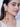 Model wearing Hazel Shell Tassel Earrings featuring natural orange shells, faux pearls and cascading chain tassels with shell drops in a Gold Tone Finish.