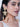 Ishani Floral Statement Earrings featuring handcrafted floral motifs, glass stones, faux pearls, cascading floral bell drops, and antique gold finish designer bridal jewelry.