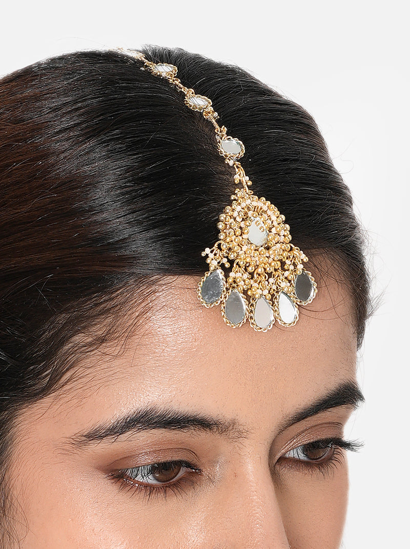 Shop Lisa Mirror Designer Maangtika handcrafted with mirror detailing, glass beads and Gold Tone Finish. Perfect for bridal wear, Haldi, Mehndi and festive occasions.