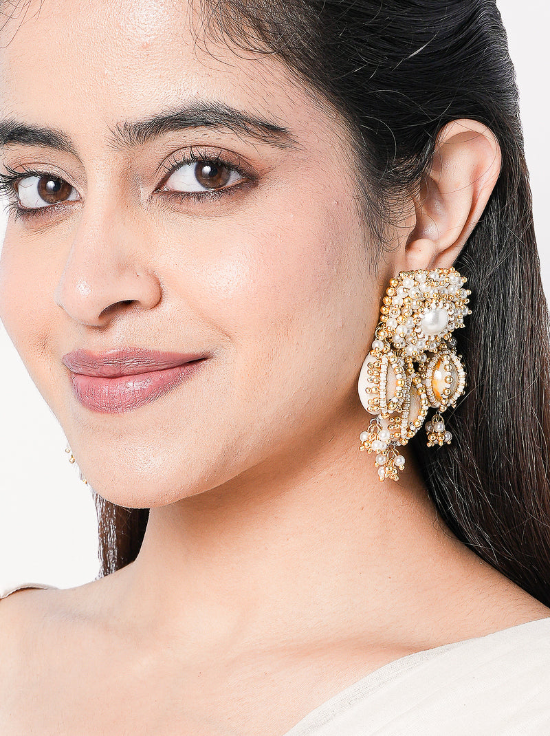 Madhubala Statement Shell Earrings featuring cowrie shell drops, faux pearl accents and intricate gold tone beadwork for bridal and festive wear.