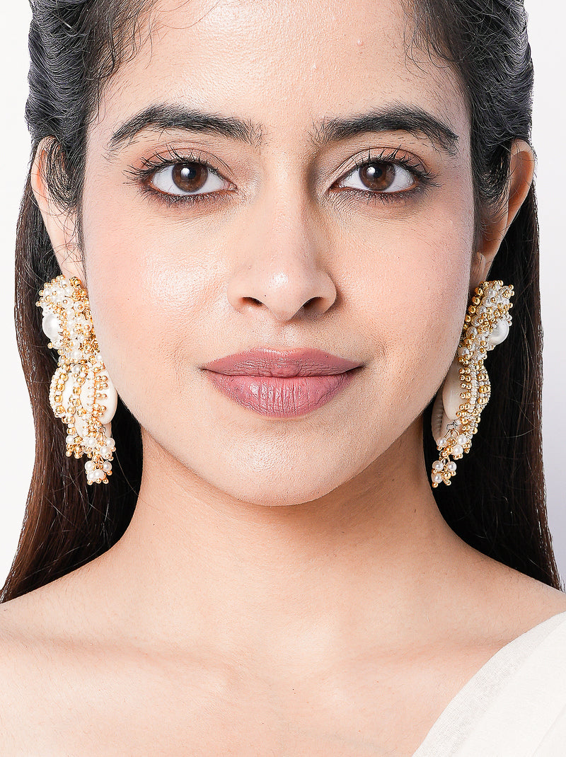 Madhubala Statement Shell Earrings featuring cowrie shell drops, faux pearl accents and intricate gold tone beadwork for bridal and festive wear.