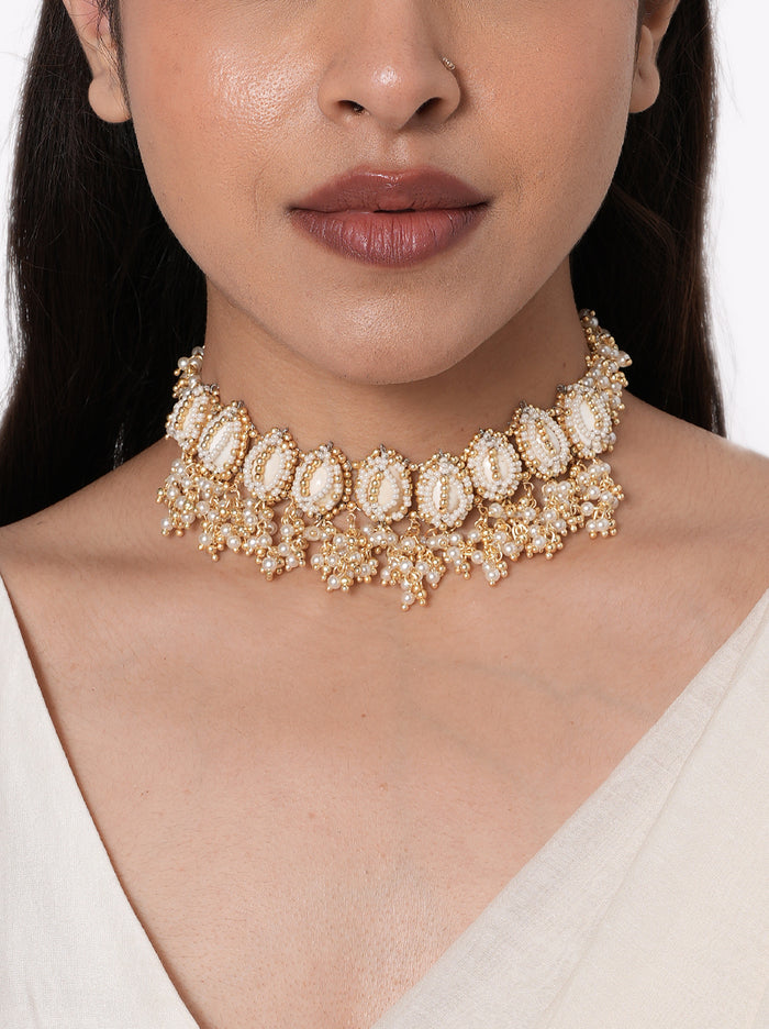 Megha Shell Ethnic Choker handcrafted with natural cowrie shells, faux pearl clusters, intricate glass bead embroidery, and a Gold Tone Finish, creating a statement bridal necklace perfect for Haldi, Mehndi, weddings, receptions, festive celebrations, and destination wedding styling.