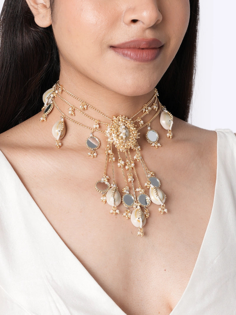 Morri Handmade Shell Choker handcrafted with natural cowrie shells, mirror accents, faux pearls, layered chains, intricate glass bead embroidery, and a Gold Tone Finish, perfect for bridal wear, haldi, mehendi, destination weddings, beach weddings, festive occasions, and statement ethnic styling.