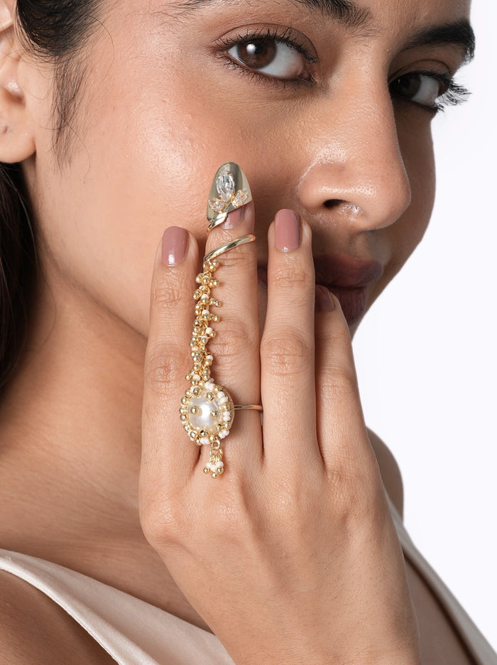 Nishi Handmade Ethnic Ring handcrafted with a faux pearl centerpiece, glass stones, delicate glass bead detailing, finger chain accents, and a Gold Tone Finish, perfect for weddings, festive occasions, cocktail parties, and elegant ethnic styling.