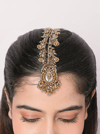 Handcrafted Parna Antique Beaded Maangtika in antique gold and silver finish featuring an oval glass stone centerpiece, intricate thread embroidery, and cascading bead detailing for bridal, wedding, and festive ethnic wear.