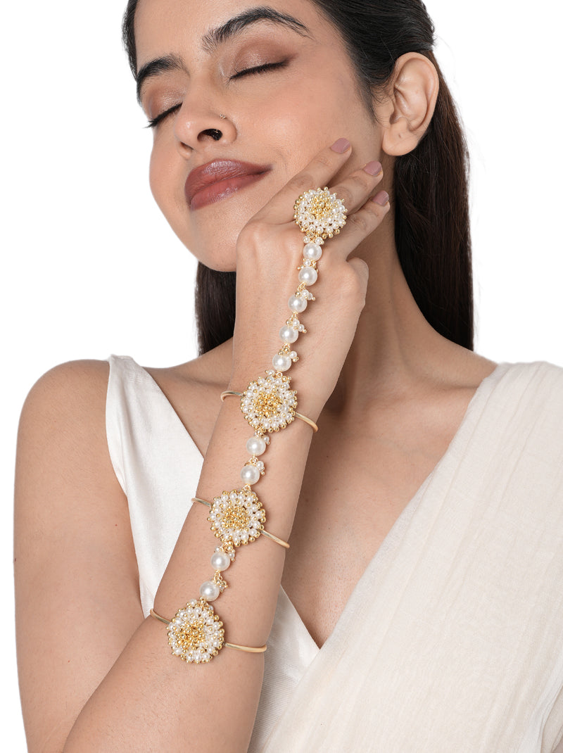 Rakhi Designer Bridal Hathphool handcrafted with floral faux pearl motifs, glass bead detailing, connected pearl strands, and a Gold Tone Finish, perfect for Haldi, Mehndi, weddings, receptions, engagement ceremonies, festive celebrations, and elegant bridal hand styling.