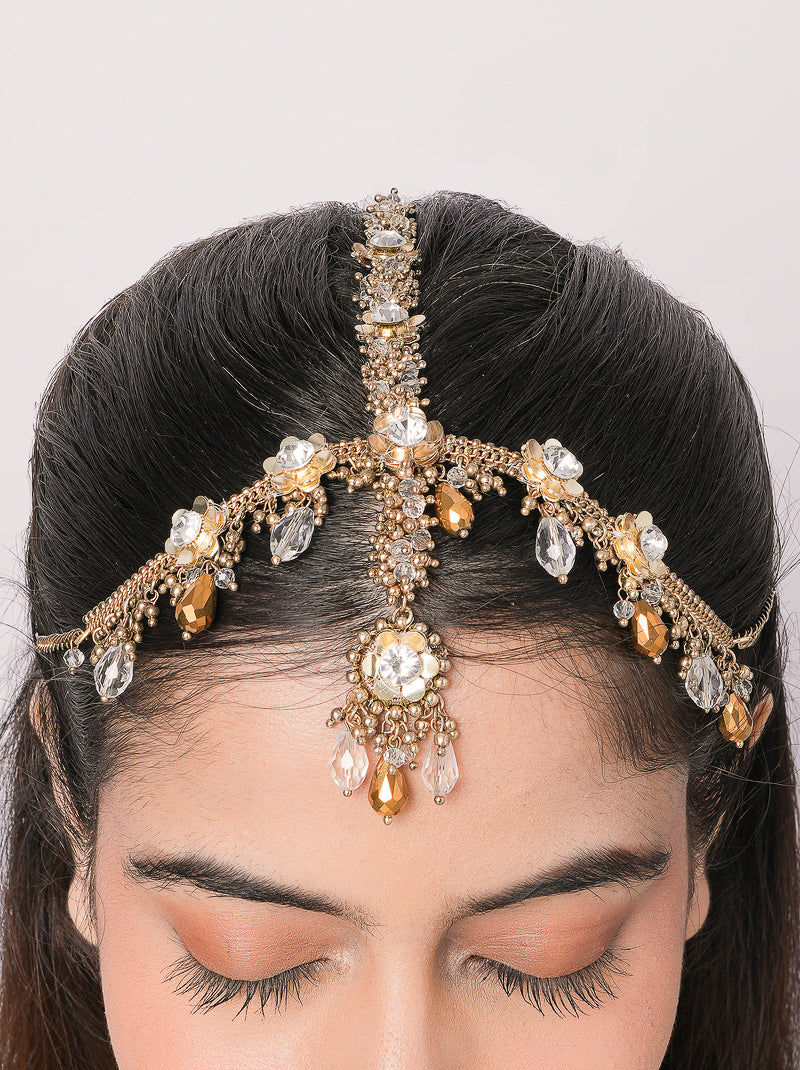Handcrafted Rakul Crystal Floral Mathapatti featuring an antique gold finish with floral crystal motifs, intricate beadwork, and champagne crystal drops for bridal and festive occasions.