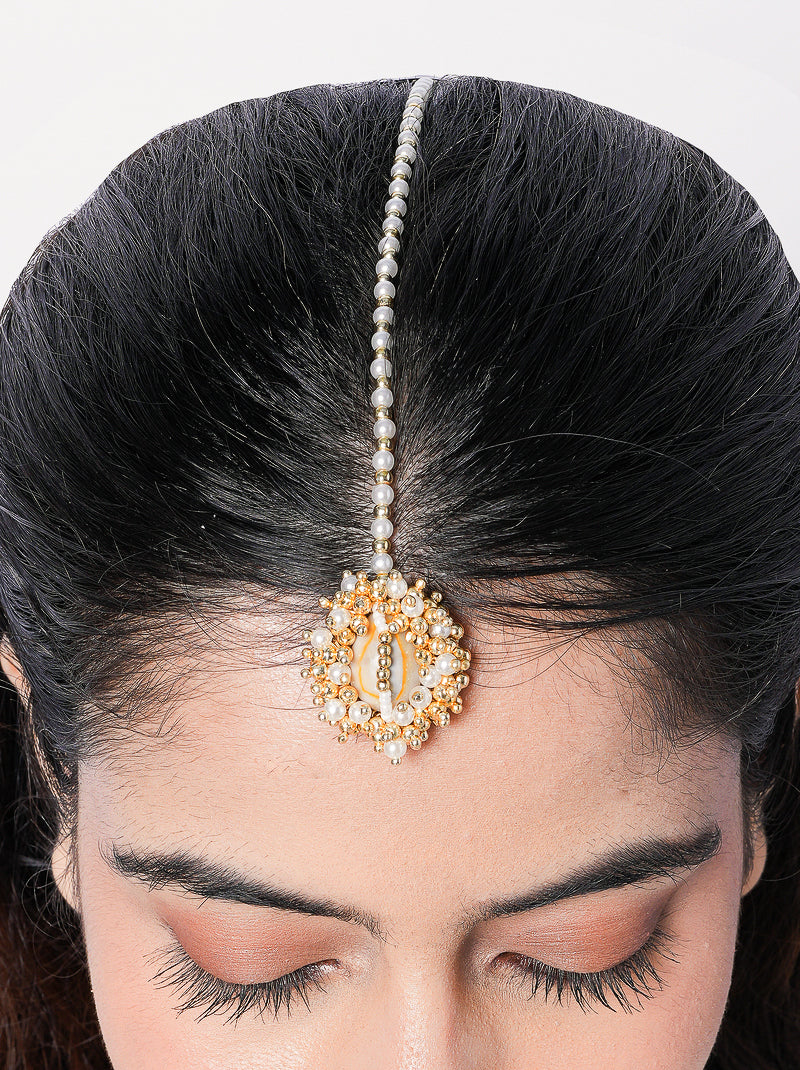 Handcrafted shell pearl maang tikka featuring cowrie shells, pearl embellishments and gold-tone detailing for bridal and festive styling.