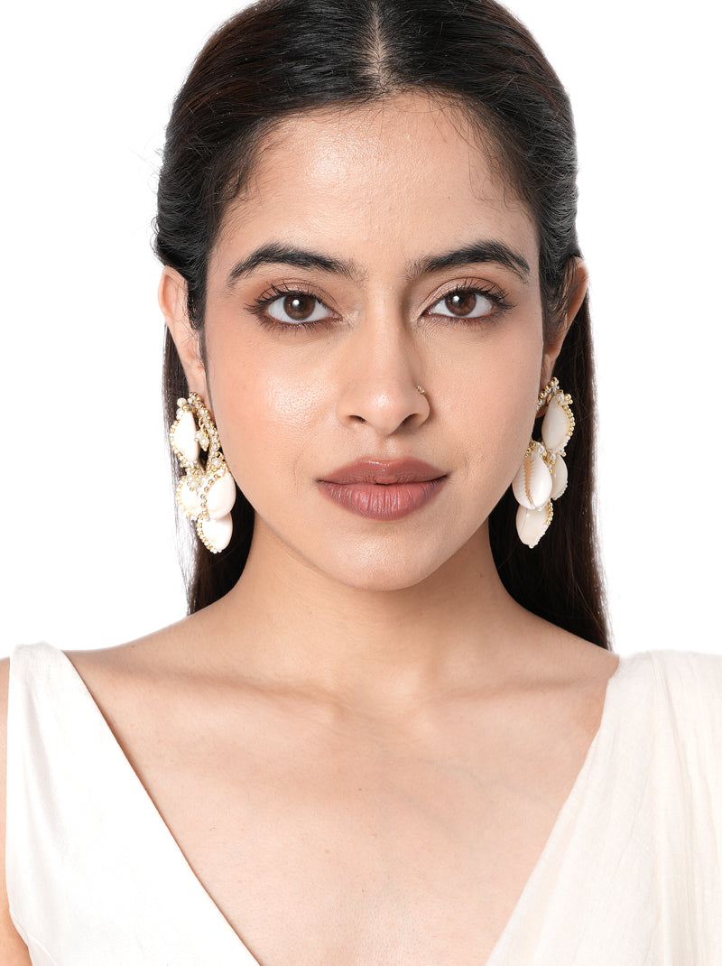 Reeva Handmade Cowrie Earrings handcrafted with natural cowrie shells, faux pearls, intricate glass bead embroidery, and a Gold Tone Finish, creating elegant statement earrings perfect for Haldi, Mehndi, weddings, receptions, destination weddings, festive celebrations, and ethnic styling.