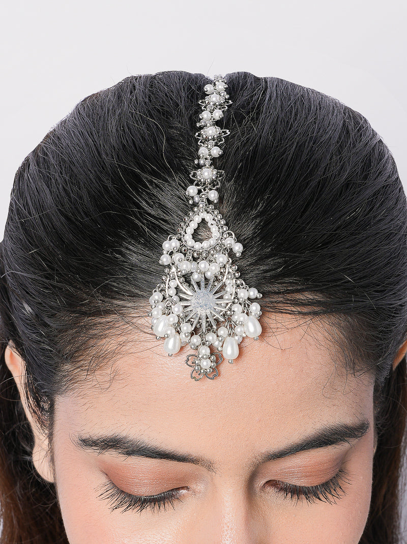 Saisha handcrafted bridal maangtika featuring faux pearl detailing, brass metal craftsmanship, and a gold tone finish for weddings, festive occasions, and traditional Indian celebrations.