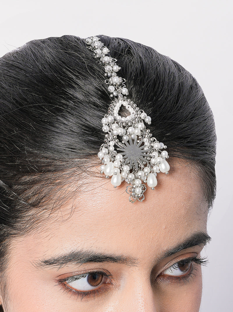 Saisha handcrafted bridal maangtika featuring faux pearl detailing, brass metal craftsmanship, and a gold tone finish for weddings, festive occasions, and traditional Indian celebrations.