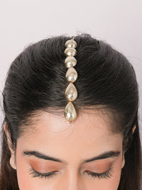 Handcrafted Sharavi Drop Pearl Maangtikka in an antique gold finish featuring polished drop-shaped metallic elements arranged in a sleek vertical design for bridal and festive styling.