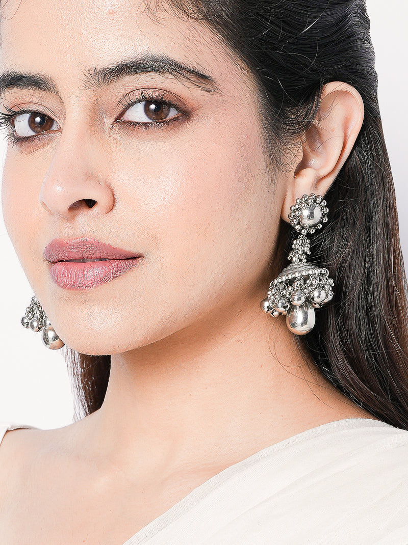 Sutradhar handcrafted statement earrings featuring intricate engraved detailing and a silver tone finish, ideal for weddings, festive celebrations, and contemporary ethnic styling.