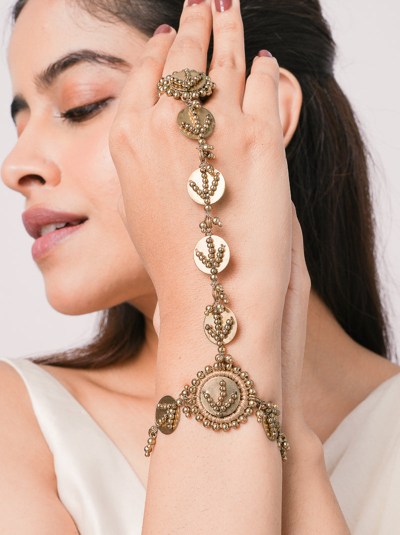 Handcrafted Tisya Heritage Shell Haathphool featuring brass metal, natural shell accents and intricate metal bead detailing with an elegant Antique Finish for bridal and festive wear.
