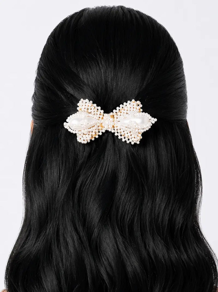 Tia Pearl Bow Hair Clip featuring handcrafted white pearl beadwork in an elegant bow design, ideal for bridal hairstyles, half-up hair, weddings, festive occasions, and sophisticated everyday styling.
