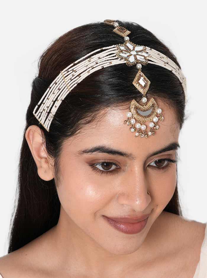Tvesa Multi Strand Maathapatti handcrafted with layered faux pearl strands, mirror floral centerpiece, crescent pendant with pearl drops, intricate glass bead detailing, and a Gold Tone Finish, perfect for Haldi, Mehndi, Sangeet, weddings, receptions, destination weddings, and elegant bridal hairstyles.
