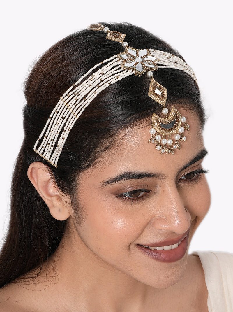 Tvesa Multi Strand Maathapatti handcrafted with layered faux pearl strands, mirror floral centerpiece, crescent pendant with pearl drops, intricate glass bead detailing, and a Gold Tone Finish, perfect for Haldi, Mehndi, Sangeet, weddings, receptions, destination weddings, and elegant bridal hairstyles.