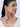 Model wearing Chandrika Pearl Jhumka Earchain featuring handcrafted faux pearls, shell accents and cascading jhumka drops attached with an elegant ear cuff in a Gold Tone Finish.