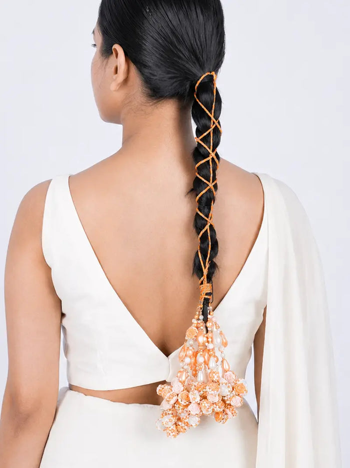 Chitra Floral Pearl Parandi handcrafted with peach fabric flowers, faux pearls, decorative brass accents and a Gold Tone Finish, designed for bridal braids, haldi, mehendi, weddings and festive hairstyles.