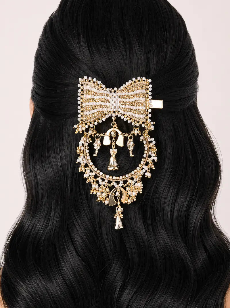 Divyansh Bow Hair Accessory featuring a handcrafted bow design with faux pearls, intricate beadwork, cascading charms and a gold tone finish, perfect for bridal hairstyles, weddings and festive occasions.