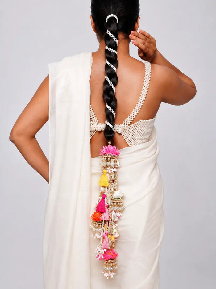 Rakhi Floral Hair Parandi handcrafted with colourful faux flowers, faux pearls, tassels, decorative brass accents and a Gold Tone Finish, designed for bridal braids, haldi, mehendi, weddings and festive hairstyles.