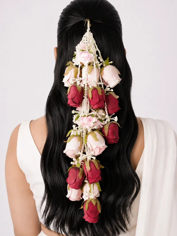 Saanvi Floral Hair Accessory featuring handcrafted red and blush pink rose blooms with cascading pearl bead strands, perfect for bridal hairstyles, Haldi, Mehendi, weddings, festive occasions, and elegant floral hair styling.