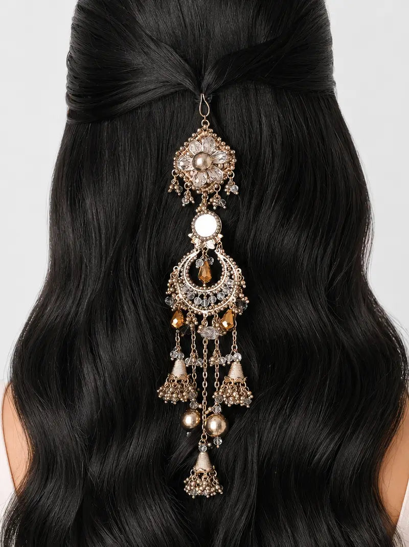 Valaya Statement Hair Accessory featuring an antique gold finish with floral motifs, mirror-inspired accents, faceted beads and cascading jhumki charms for bridal, festive and traditional hairstyles.