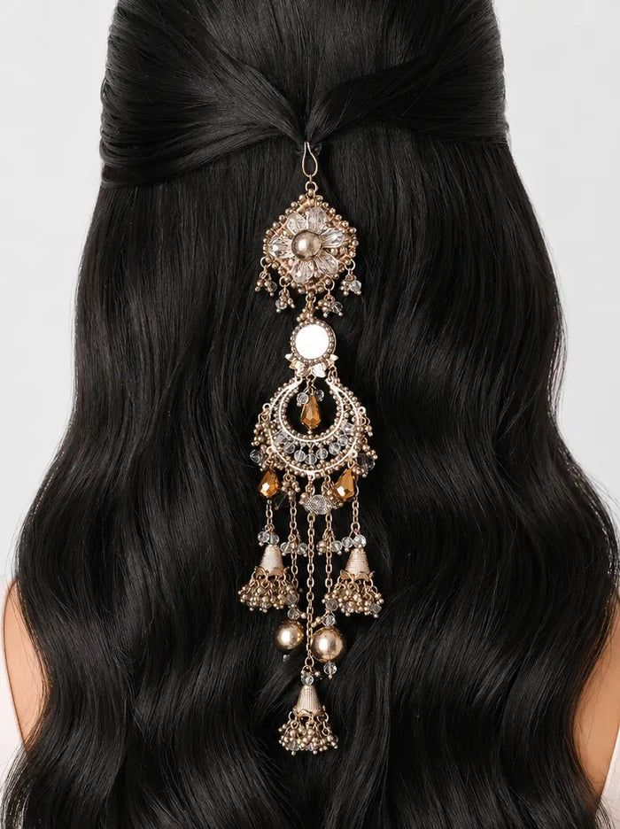 Valaya Statement Hair Accessory featuring an antique gold finish with floral motifs, mirror-inspired accents, faceted beads and cascading jhumki charms for bridal, festive and traditional hairstyles.